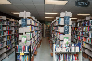 Looking down the aisle of a library, with shelves of books on either side.