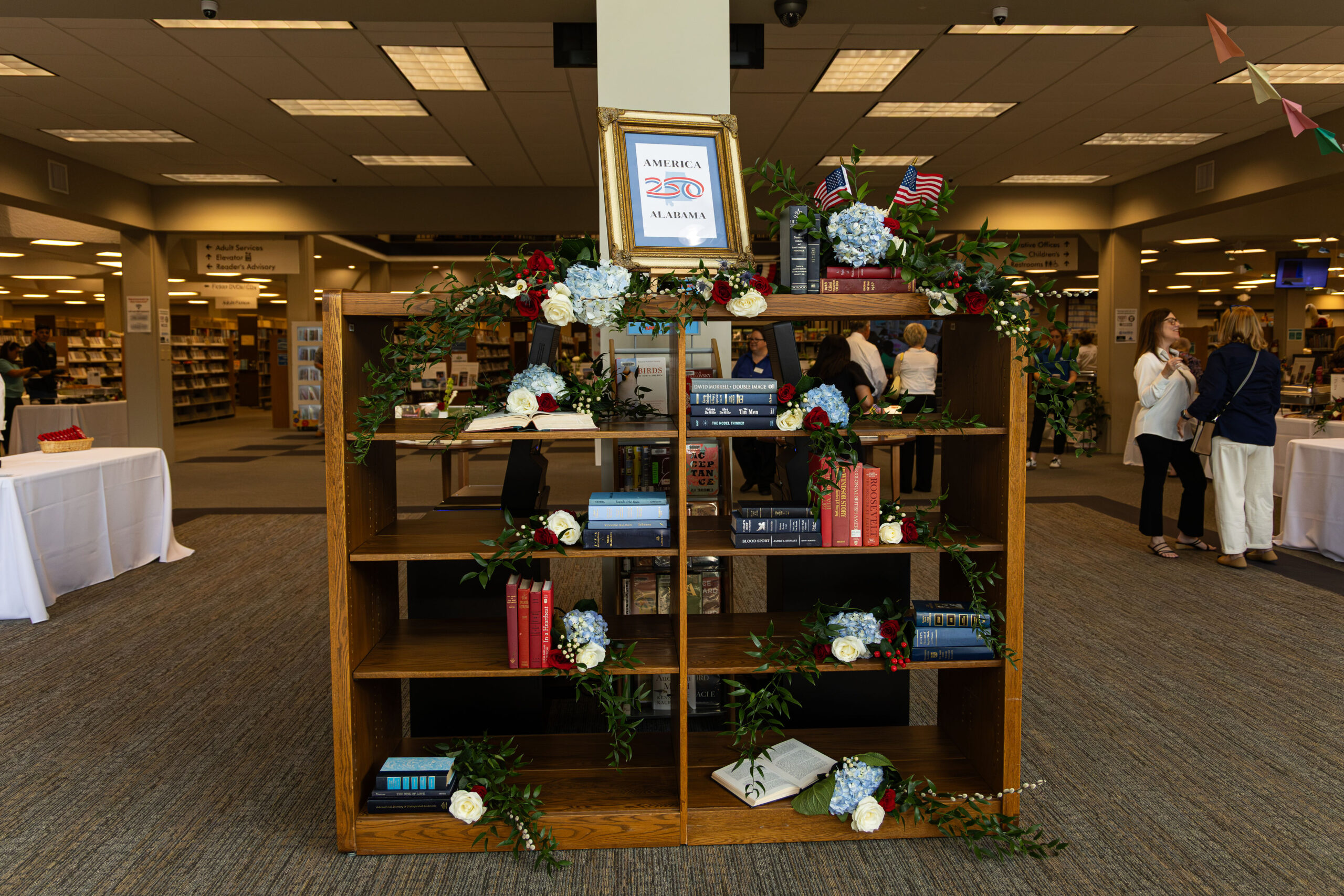 Bookshelf with books and decorated with flowers
