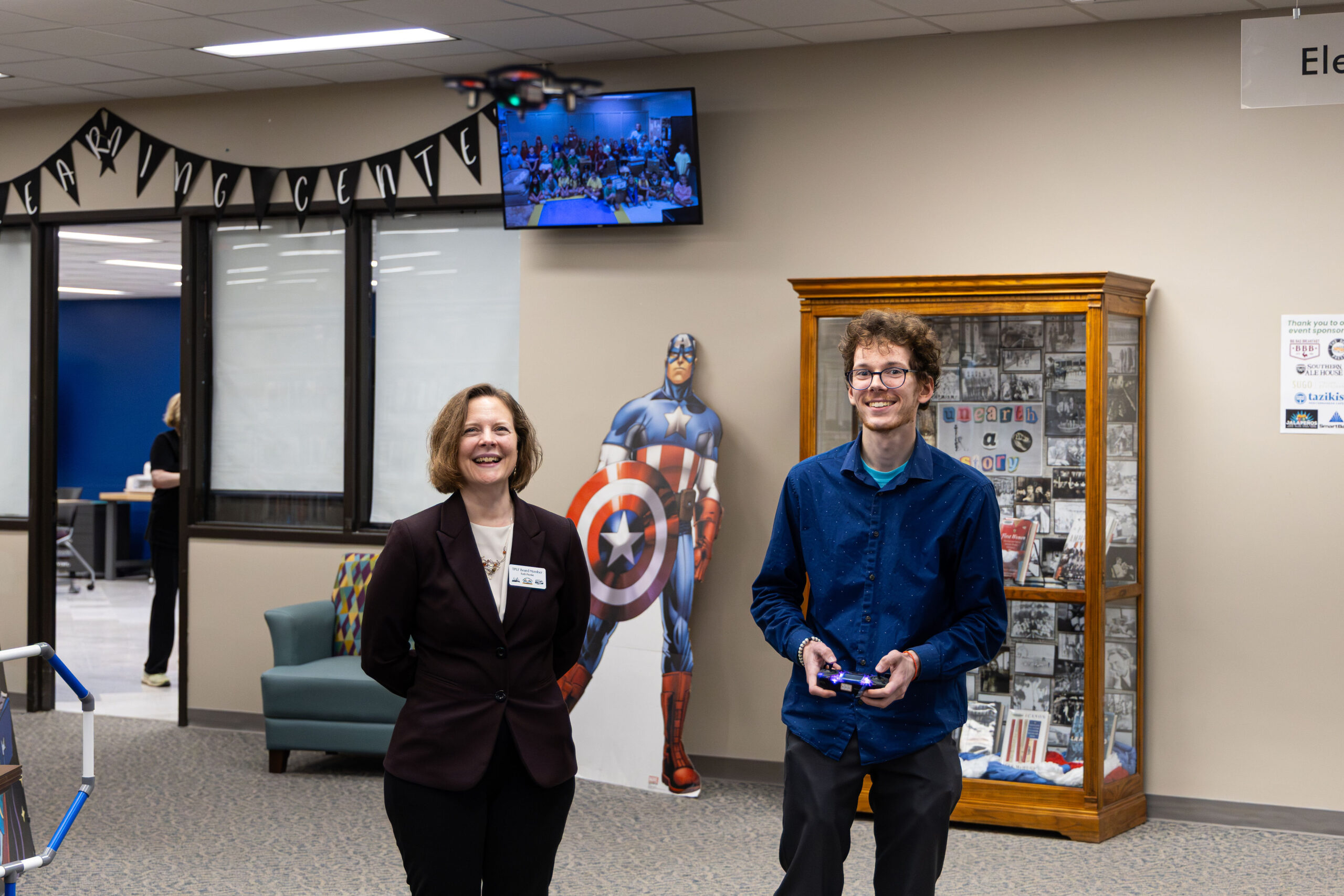A staff member demonstrating a small drone for a TPL Foundation Board member