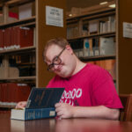 Volunteer seated and reading a book
