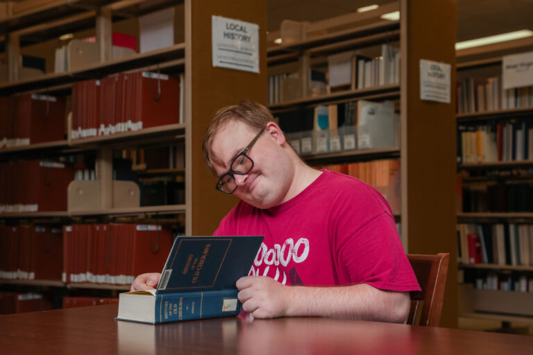 Volunteer seated and reading a book