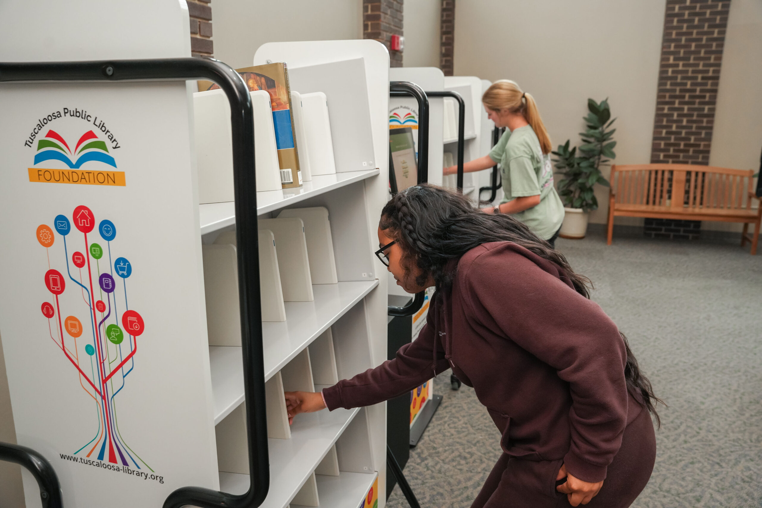 Individual looking at books on a shelf