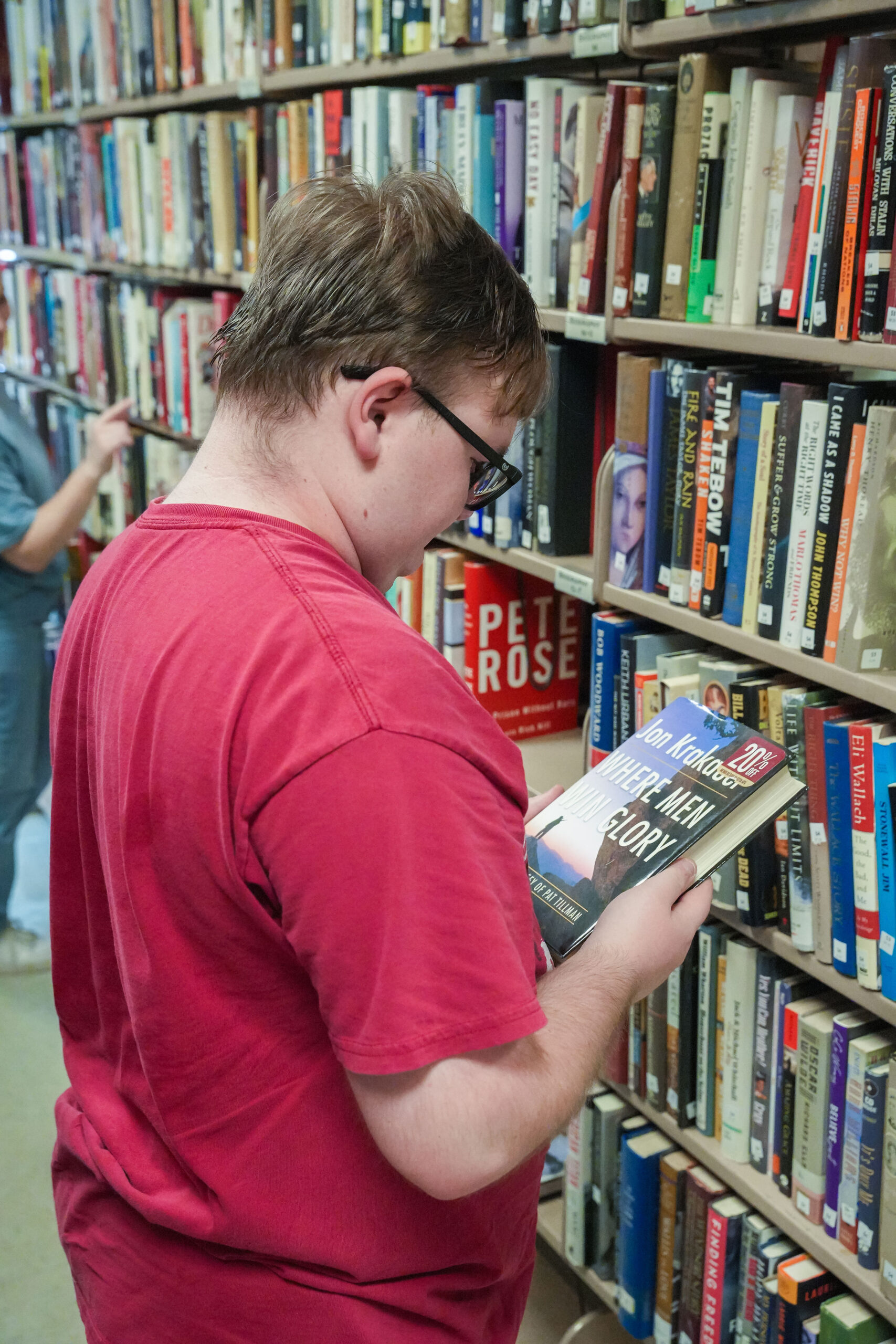 Volunteer selecting a book from a library shelf